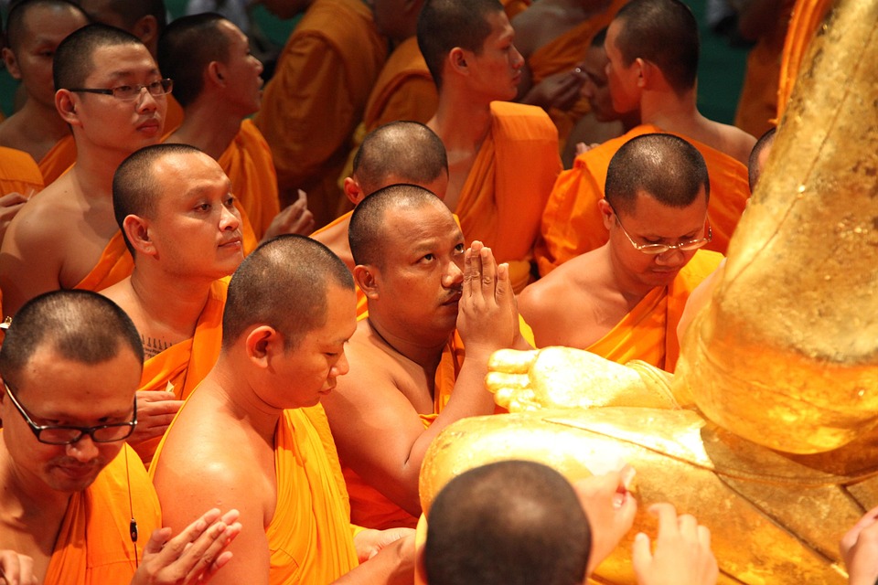 Monks paying reverence to the golden statue of Phramongkolthepmuni